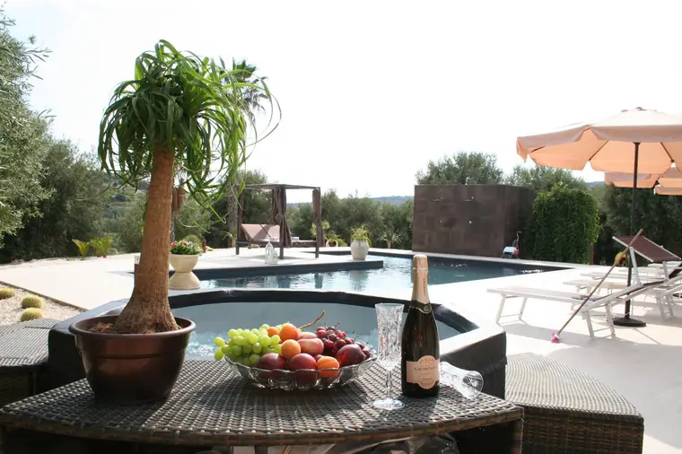 Tavolo con frutta e spumante a bordo piscina